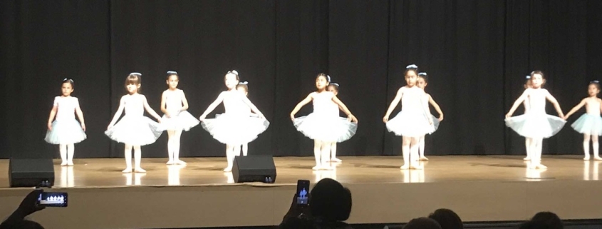 Grupo de niñas realizando una actuación en el escenario como parte de las actividades complementarias y extraescolares del centro.