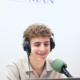 Alumno grabando en el estudio de radio dentro de las instalaciones colegio, usando micrófono y auriculares.