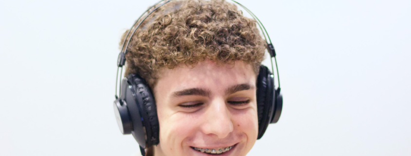 Alumno grabando en el estudio de radio dentro de las instalaciones colegio, usando micrófono y auriculares.