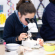 Alumna observando muestras científicas al microscopio en una práctica del colegio internacional madrid.